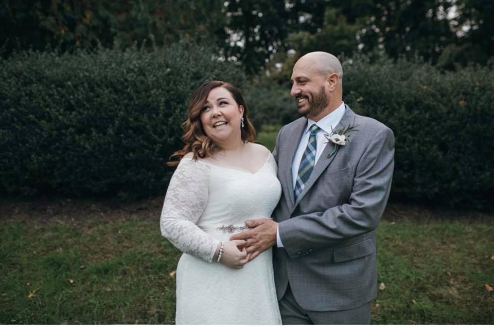 October Wedding couple standing together smiling on back lawn